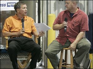 Republican gubernatorial candidate John Kasich, left, and Mike McAlear of Service Spring Corp. speak during a discussion in Millbury last month.