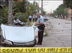 A Toledo Police officer examines the front third of the car as it rests in the intersection of Broadway and Walbridge. The back part can be seen in the background stuck in the bushes.<br>
<img src=http://www.toledoblade.com/graphics/icons/photo.gif> <font color=red><b>VIEW GALLERY:</b></font> <a href="/apps/pbcs.dll/gallery?Avis=TO&Dato=20100824&Kategori=NEWS16&Lopenr=824009998&Ref=PH"> <b> Fatal Wreck on Broadway</b></a> 