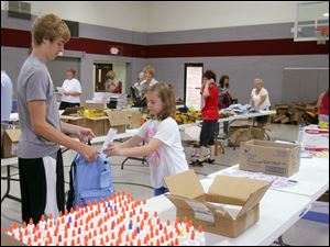 NBRN packs25p  8/18//2010 The Blade/Lisa Dutton Lambertville,MI l to r-- Devin Hice,15 of Bedford, gets rulers put into his backpacks by Victoria Dierks,10 of Lambertville,MI. Volunteers will be sorting and packing school supplies that were collected over the last month for the annual back-to-school backpack program. Get pictures of the volunteers with the supplies. The backpacks will be distributed this week. The volunteers will begin at 9 a.m.