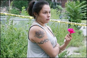 Juanita Kneisley, 24, of Boalt Street, holds a rose as she recounts the violent crash.
