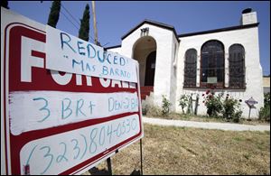 After home sales in souther California plunged 21.4 percent last month compared to July 2099, some owners are lowering prices. This reduction sign is bilingual.