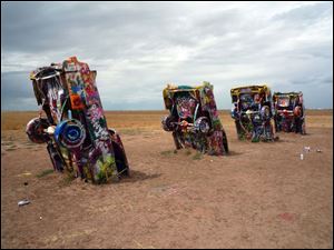 Wild graffiti covers the nose-down cars impaled into the ground at Cadillac Ranch in Amarillo, Texas.