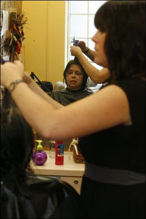 Jamie Wells, an instructor and cosmetologist who volunteers with the Finished Image program, gives Janet Boyce a haircut.