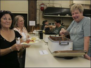Kathy Jarret, left, and Jen Teschner line up for some spaghetti being served by Lyn Moeltner, right foreground, and Cathie Slabaugh during the fund-raiser to benefit church custodian Tony Leno, who is still hospitalized.