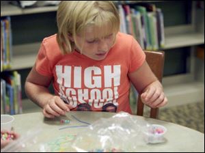 Meg Murdock, 9, of Petersburg finds some beads to string together.