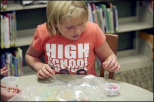 Meg Murdock, 9, of Petersburg finds some beads to string together.