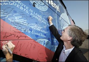 Slug:  CTY REVOLT31p  Date:  08312010        The Blade/Andy Morrison       Location:   Bowling Green      Caption: Congressman Bob Latta signs the side of the Spending Revolt Bus in Bowling Green, Tuesday, 08312010. Summary:
