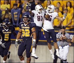 Arizona's David Roberts (81) and David Douglas (85) celebrate Douglas' touchdown catch in the first quarter while Toledo's Dan Molls leaves the field. Arizona racked up 518 yards of offense.<br>
<img src=http://www.toledoblade.com/graphics/icons/photo.gif> <font color=red><b>VIEW GALLERY:</b></font> <a href=