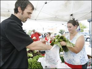 Tony House, executive chef at Navy Bistro, buuys produce from Becky Kornmeier at Andy Keil's Greenhouse stall at the Perrysburg Farmers' Market.
