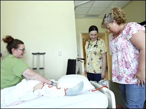 Bri Mullinger gives nurse Sarah Schwen and her mother Teri Mullinger, an update from her bed in Toledo Children's Hospital.