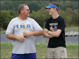 Coach Tom Walentowski confers with Tim Berta, his former player who now is a volunteer assistant football coach. Walentowski said it was tough to see Berta go through a grueling rehabilitation.