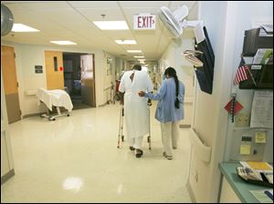 Tony Leno uses a walker and the help of physical therapist Neelam Patel on one of his last days as a patient in St. Charles.