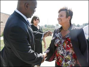 Mayor Mike Bell greets U.S. EPA Administrator Lisa Jackson after a news conference near the Maumee River in East Toledo.