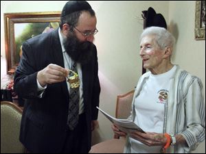 Rabbi Yossi Shemtov of Chabad House-Lubavitch offers honey to Sarah London in preparation for Rosh Hashanah, which began at sunset Wednesday.