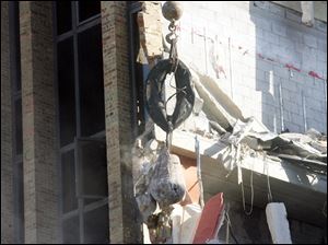 A wrecking ball smashes into the brick walls.