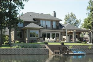 The back view of the home highlights its wonderful location on the water in Stone Oak.