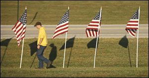 Josh Morgan walks past the flags he helped place outside Harrison High near West Lafayette, Ind., to mark the 9/11 anniversary.