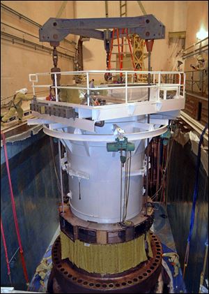 During a previous shutdown at Davis-Besse, technicians work from scaffolding to repair components of the reactor.