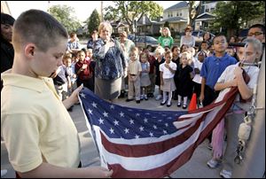 CTY remember11p  9/10/10  The Blade/Dave Zapotosky John Martis, 11, left, and Charlene Palmer, 11, right, raise the U.S. flag as students and staff at Navarre Elementary School in East Toledo hold a brief ceremony to remember the terrorist attacks of September 11, 2001, Friday September 10, 2010.  Both are sixth grade students. A moment of silence was observed and essays were read by two sixth grade students, Paul Espino, and Locadio Ruiz. Summary:  9/11 observation at Navarre Elementary School.