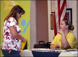 Kim Betway, left, of Monroe gets information about child safety from Amy Zarend of the Great Start Collaborative of Monroe during the Nevaeh Buchanan event at the Moose Lodge.