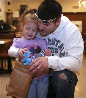 Dion Elmore and daughter Alexis, 2�, look through a goody bag she received at the event. Mr. Elmore helped search for Nevaeh.