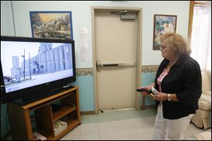 Patricia Staley watches the news of the grain elevator fire from the East Toledo Senior Center. Ms. Staley lives on Utah Street near the elevator and was forced to leave her home. 