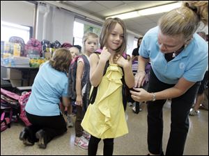 Slug : NBRE backpacks09p  Date:  09092010        The Blade/Andy Morrison       Location: Rossford   Caption:  Kindergartner Audrey Miller gets help putting on a backpack to model from Kay Koevenig, chair of the Backpack to the Future Program at Glenwood Elementary, Thursday, 09092010.    The supplies were donated by members of the Owens Community College Alumni Association. Summary:  EDS. supplies were not passed out today. This was a staged media event basically.