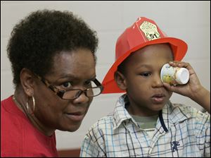 NBRW FUNFAIR15p   The Blade/Lori King  09/11/2010  Health screen volunteer Monica Wilkins helps Sincere Richardson, 4, during his vision test during the Back to School Kids Fun Fair at the Body of Christ Fellowship Church in Toledo, Ohio.