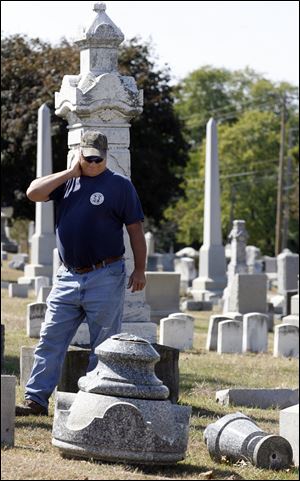 Roy Wise surveys damage at McPherson Cemetery in Clyde after vandals struck. Cemetery crews have begun repairing or resetting almost 200 markers. 