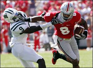Ohio State wide receiver DeVier Posey is tackled by his brother, Julian, a senior cornerback for Ohio.