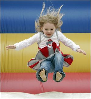 Haley Getzinger, 3, bounces down a huge inflatable slide, one of the activities for children on Harrison Rally Day.