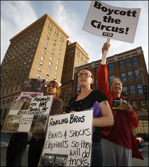 Jessica Campbell, Terri Miller, and Leonard Hargrave, from left, rally outside Huntington Center, where the Ringling Bros. and Barnum & Bailey Circus performed Wednesday night. About 15 supporters of People for the Ethical Treatment of Animals participated in the protest, alleging the circus mistreats animals.