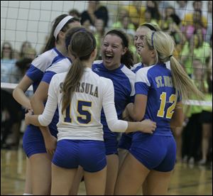 Veronica Zimmerman is surrounded as St. Ursula celebrates a point in Wednesday night's match against Notre Dame. The Arrows improved to 11-1, 7-0 in the City League.