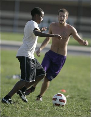 Edwin Mbuthia,foreign exchange student from Kenya, moves the ball against Waite teammate Ron Cornelison in practice. Mbuthia, a sophomore, has scored a goal and has two assists for the Indians.
