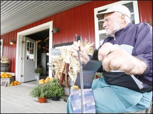 Lyle Crots of Ottawa Lake entertains orchard visitors with his musical saw, which he's been playing for 10 years.