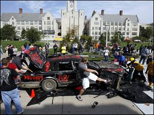 Slug: CTY peprally01p                               9/30/2010 The Blade/Amy E. Voigt                  Toledo, Ohio  CAPTION:  Students smash up a donated Towncar from ABC Auto Parts, during a pep rally at the Student Union to get students and staff excited before the Rockets homecoming game this Saturday against the Wyoming Cowboys.