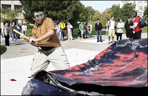 Slug: CTY peprally01p                               9/30/2010 The Blade/Amy E. Voigt                  Toledo, Ohio  CAPTION:  Osama Nazzal, a senior from Toledo, takes a whack at a donated Towncar from ABC Auto Parts, during the traditional car  smashing at a pep rally at the Student Union to get students and staff excited before the Rockets homecoming game this Saturday against the Wyoming Cowboys.