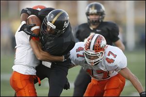 Perrysburg's Tyler Gordon is tackled by Southview junior JQ Bowers, left, and junior Jay Fisher. 