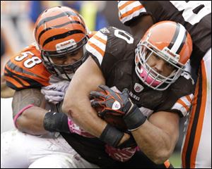Browns running back Peyton Hills fights for yards against Bengals linebacker Rey Maualuga.