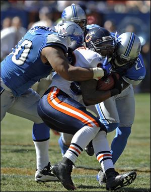 Detroit's Ndamukong Suh, left, and Alphonso Smith stop Chicago's Matte Forte. The Lions are still looking for their first win.