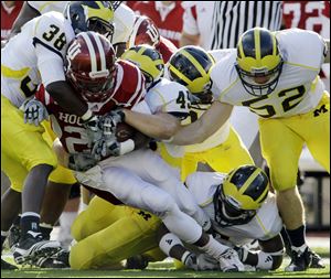 Michigan defenders Terrence Talbott (38) and Obei Ezeh (45) tackle Indiana running back Nick Turner.