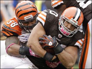 Browns running back Peyton Hills fights for yards against Bengals linebacker Rey Maualuga. 