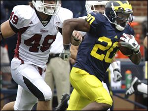 Michigan running back Michael Shaw (20) breaks downfield in front of Massachusetts lineman Galen Clemons during the fourth quarter of the game Saturday, September 18, 2010.