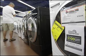 A shopper inspects washing machines in California. Orders for durable goods such as appliances fell 1.5 percent in August.