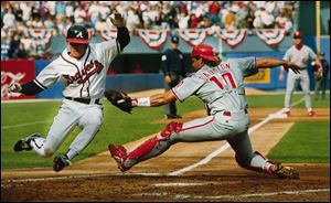 Philadelphia Phillies catcher Darren Daulton tries to tag the Atlanta Braves' Jeff Blauser during the 1993 National League Championship Series.