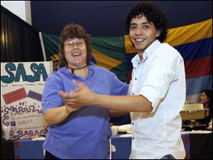 CTY international09p  Toledo resident Donna Eckloff (cq), left, dancing with Eduardo Diaz (cq), president of the South American Students Association in front of their table. The 19th annual food festival presented by the International Students Association at the University of Toledo in Toledo, Ohio on October 8, 2010. Jetta Fraser/The Blade