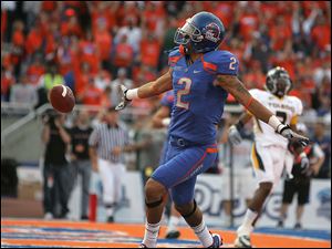 Boise State's Austin Pettis, who lined up as the holder on the extra point kick try, celebrates after scoring two points in the first half on a trick play after the Broncos' first touchdown. 