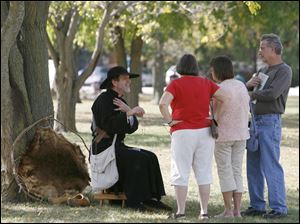 Slug: CTY CAMP10p Date: 10092010  The Blade/Andy Morrison   Location: Bowling Green Caption: Dressed as a Jesuit missionary, Craig McGirr, left, Bridgman, Michigan, speaks to Harriet Treaaway, left, Toledo, and June and Don Goetz, Helena, at the Revolutionary War encampment at the Wood County Historical Center & Museum, Saturday, 10092010.
