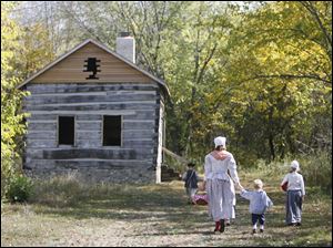 Slug: CTY CAMP10p Date: 10092010  The Blade/Andy Morrison   Location: Bowling Green Caption: Anna McMaster, MD, holds hte hand of her two-year-old son Elliott as they and daughter Elyse McMaster, 9, head to a building to have a picnic lunch at the Revolutionary War encampment at the Wood County Historical Center & Museum, Saturday, 10092010.