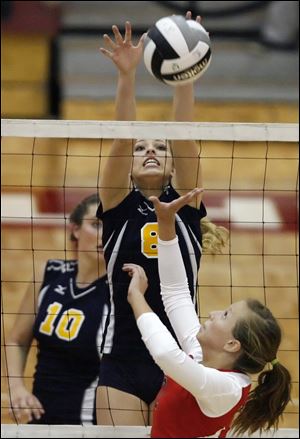Notre Dame's Jocelyn Uchic (8) leaps for the ball against Central Catholic's Maggie Gilmore in the second semifinal at the Sullivan Center.